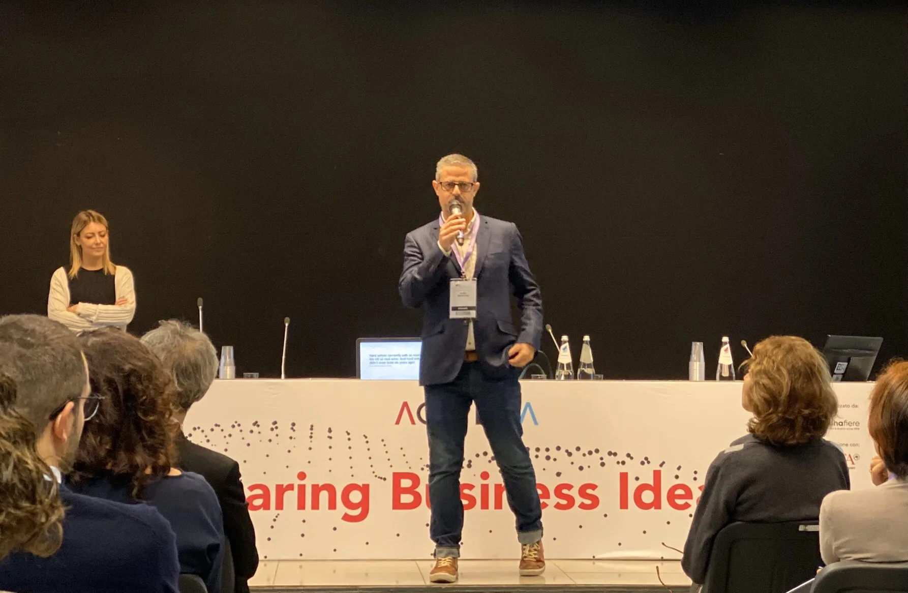 André presenting in front of an audience.